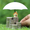 Piles of coins with a house on top and an umbrella covering